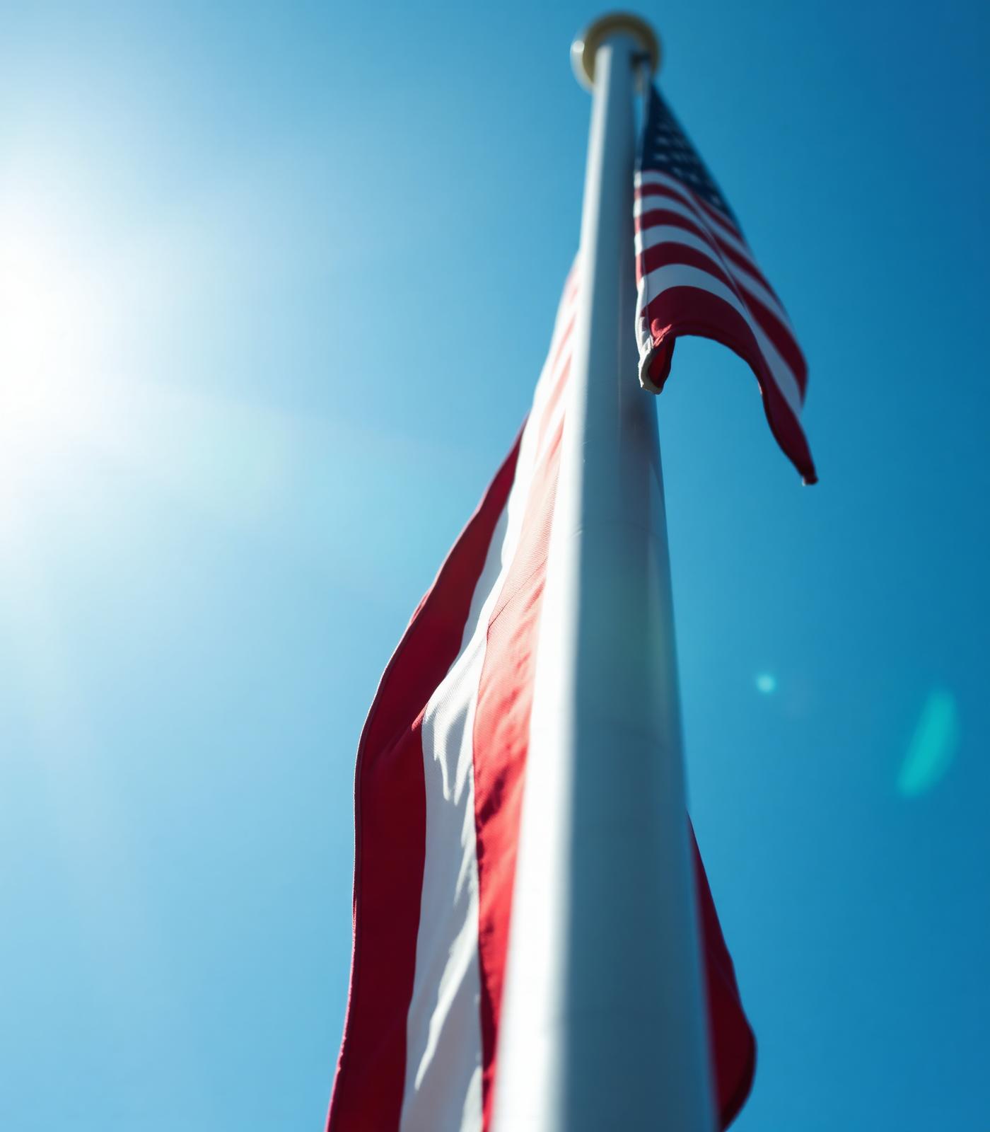 A crisp new American flag being raised against a bright sky